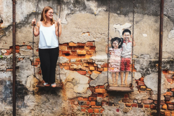 Redakteurin Linda schaukelt mit den Kindern, die als Street-Art in Georgetown zu finden sind