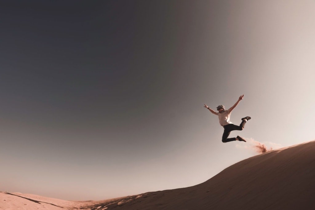 Frau springt durch Wüste