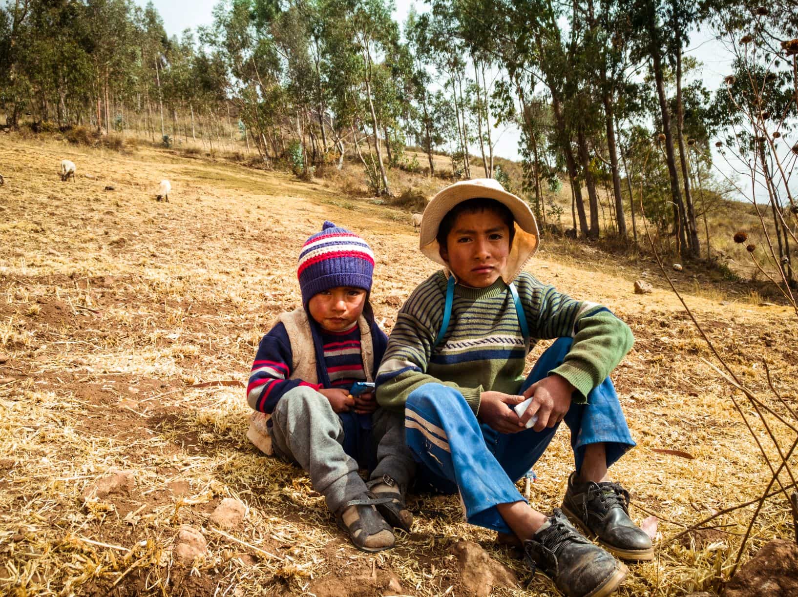 Zwei Jungen sitzen in Peru auf einer Wiese