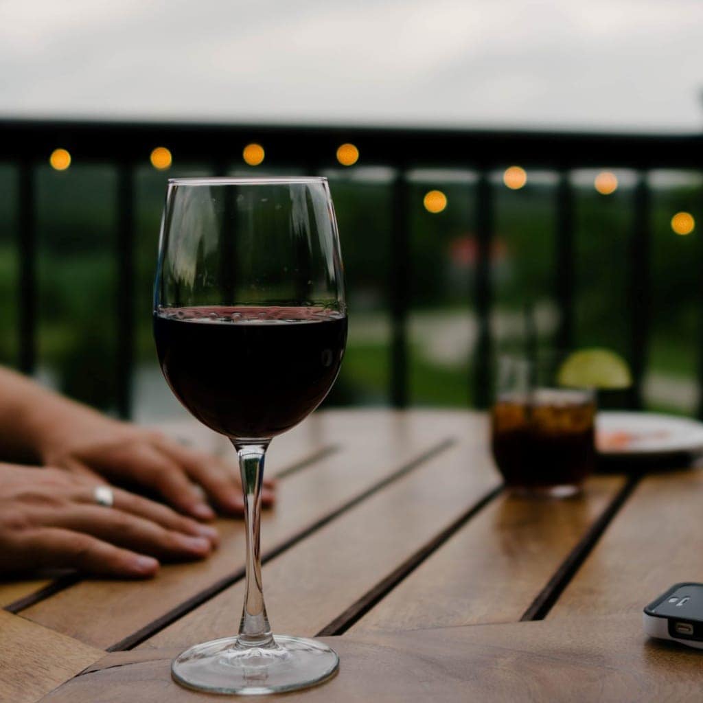 Glas Rotwein auf Holztisch