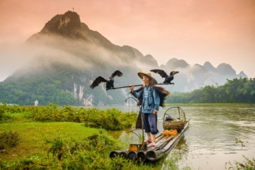 Älterer Mann in China steht auf seinem Floß
