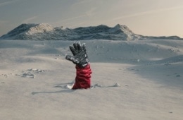 Skifahrer streckt Hand aus Schnee