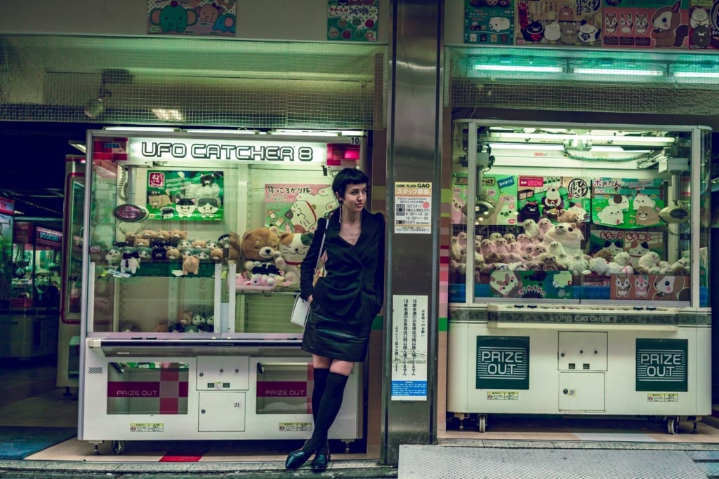 Frau vor Plüschtierautomaten in Tokio