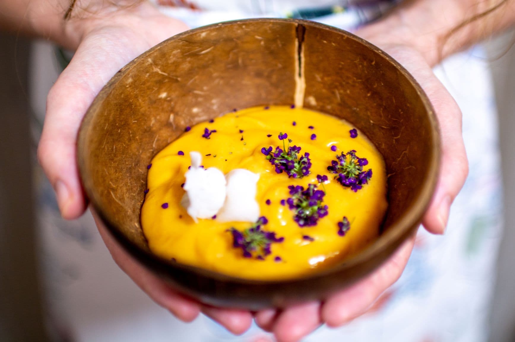 Frau hält Schüssel mit Papaya-Mango-Reis-Püree in der Hand