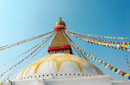 Tempelspitze, die mit bunten Fahnen und Gesicht-Malerei versehen ist, in der Hauptstadt Nepals: Kathmandu