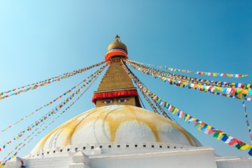 Tempelspitze, die mit bunten Fahnen und Gesicht-Malerei versehen ist, in der Hauptstadt Nepals: Kathmandu
