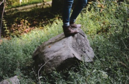 Wanderer steht in der Natur auf einem großen Stein