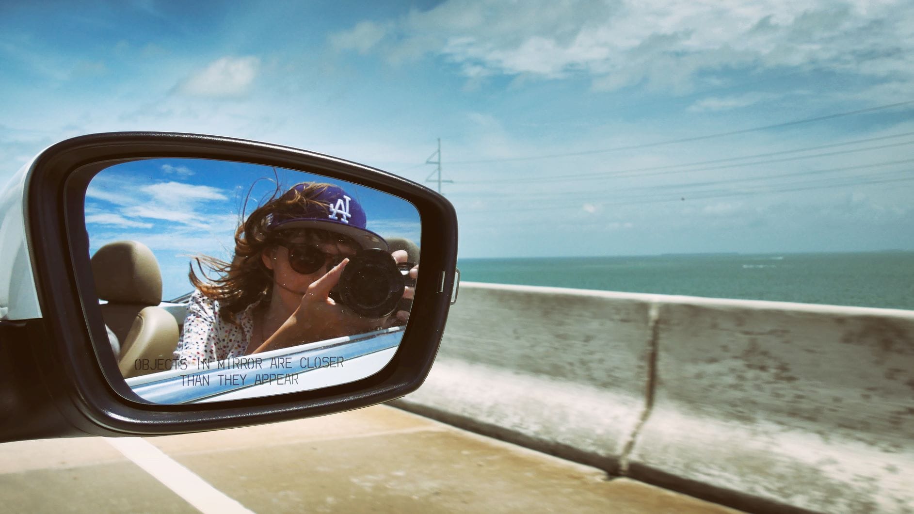 Frau fotografiert mit Kamera während der Autofahrt
