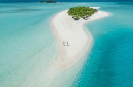 Pärchen spaziert über kleine Privatinsel in den Malediven. Dort versprechen die Resorts Luxus pur.