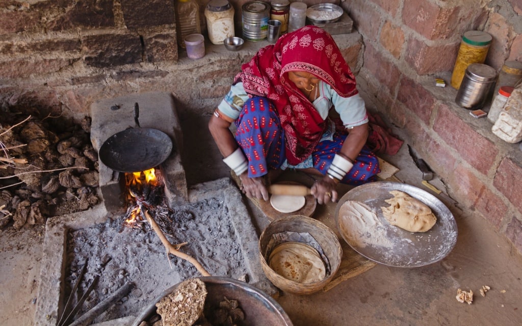 Diese indische Frau backt Naan-Brot.