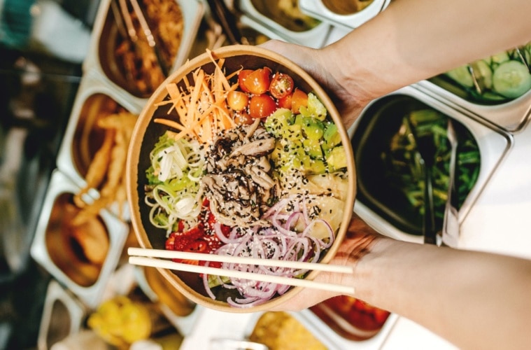 Person hält Schüssel Gemüse in der Hand