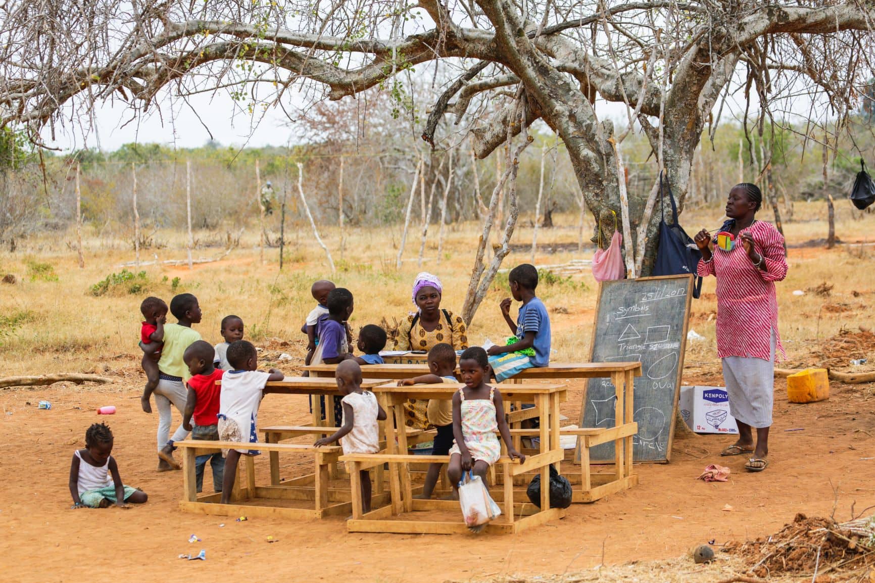 Grundschul-Kinder sitzen im Freien in Kenia 