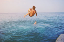 Wild Swimming in Deutschland: Ein Mann springt in einen See.