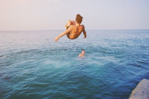 Wild Swimming in Deutschland: Ein Mann springt in einen See.