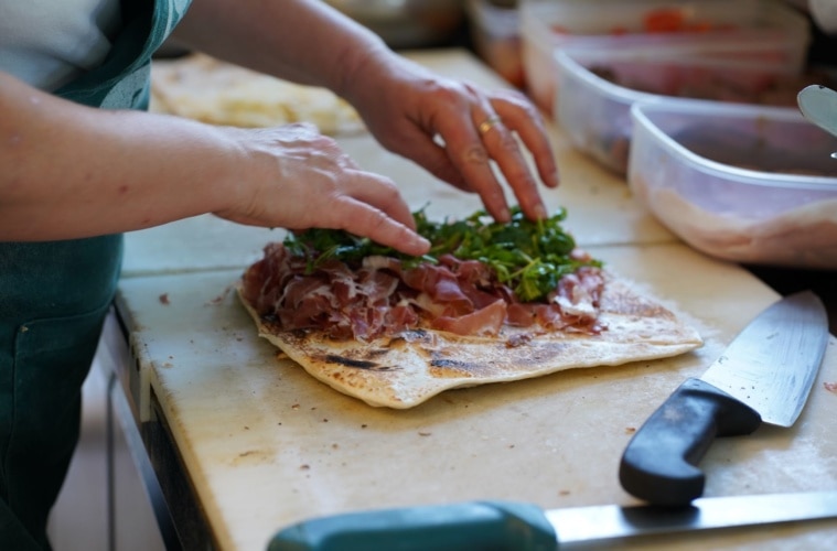 Hände bereiten Piadina zu