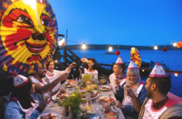 Menschen feiern eine traditionelle Kräftskiva mit Krebsen, Papierhüten und Lampions an einer festlich gedeckten Tafel in Schweden.