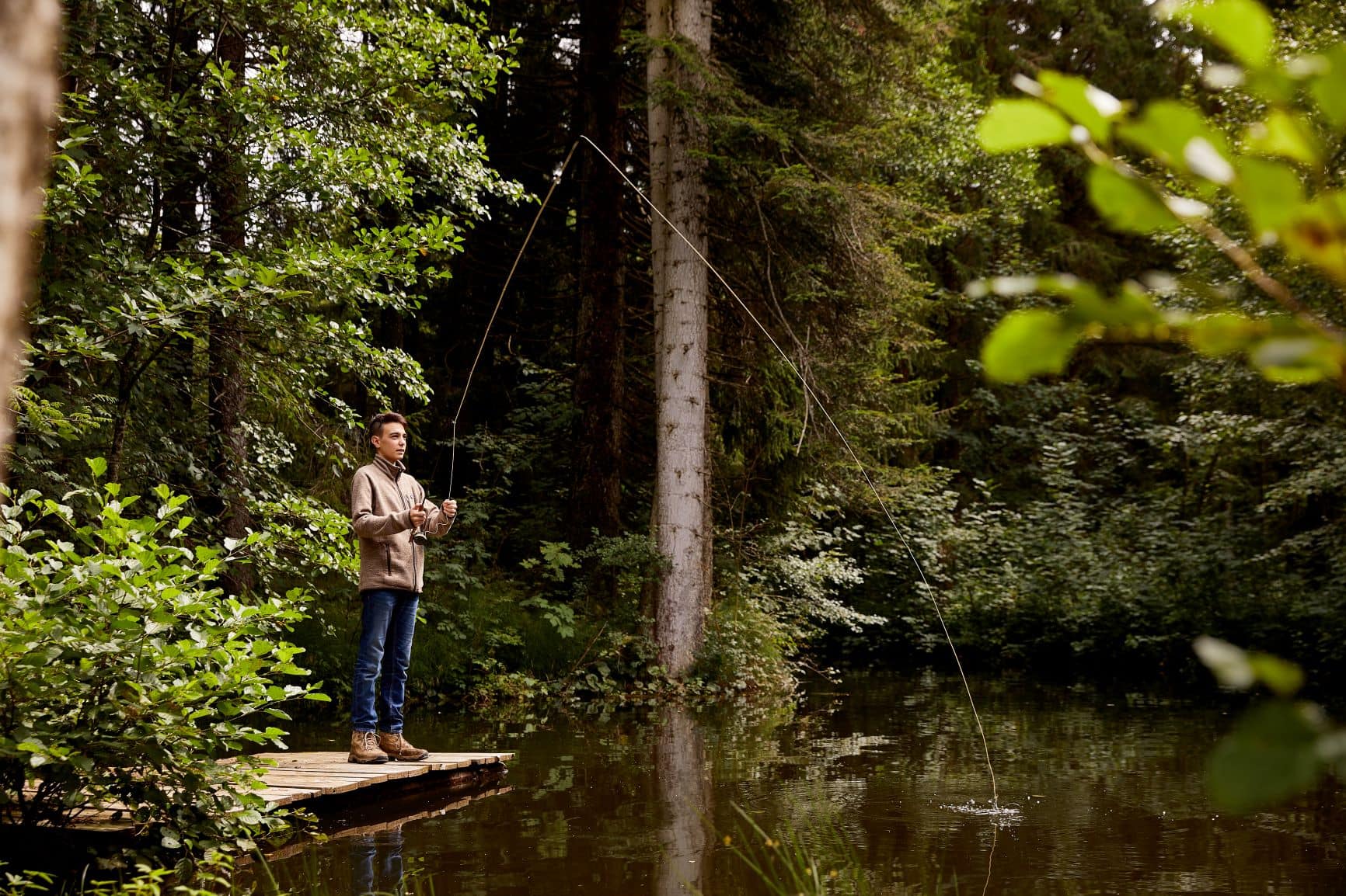 Junge beim Angeln im Wald