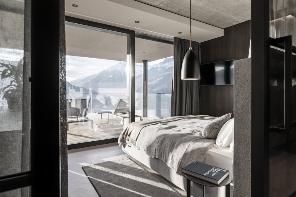 Schlafzimmer im Apartment 7 in Schenna mit raumhohen Fenstern und Blick auf die Südtiroler Berge