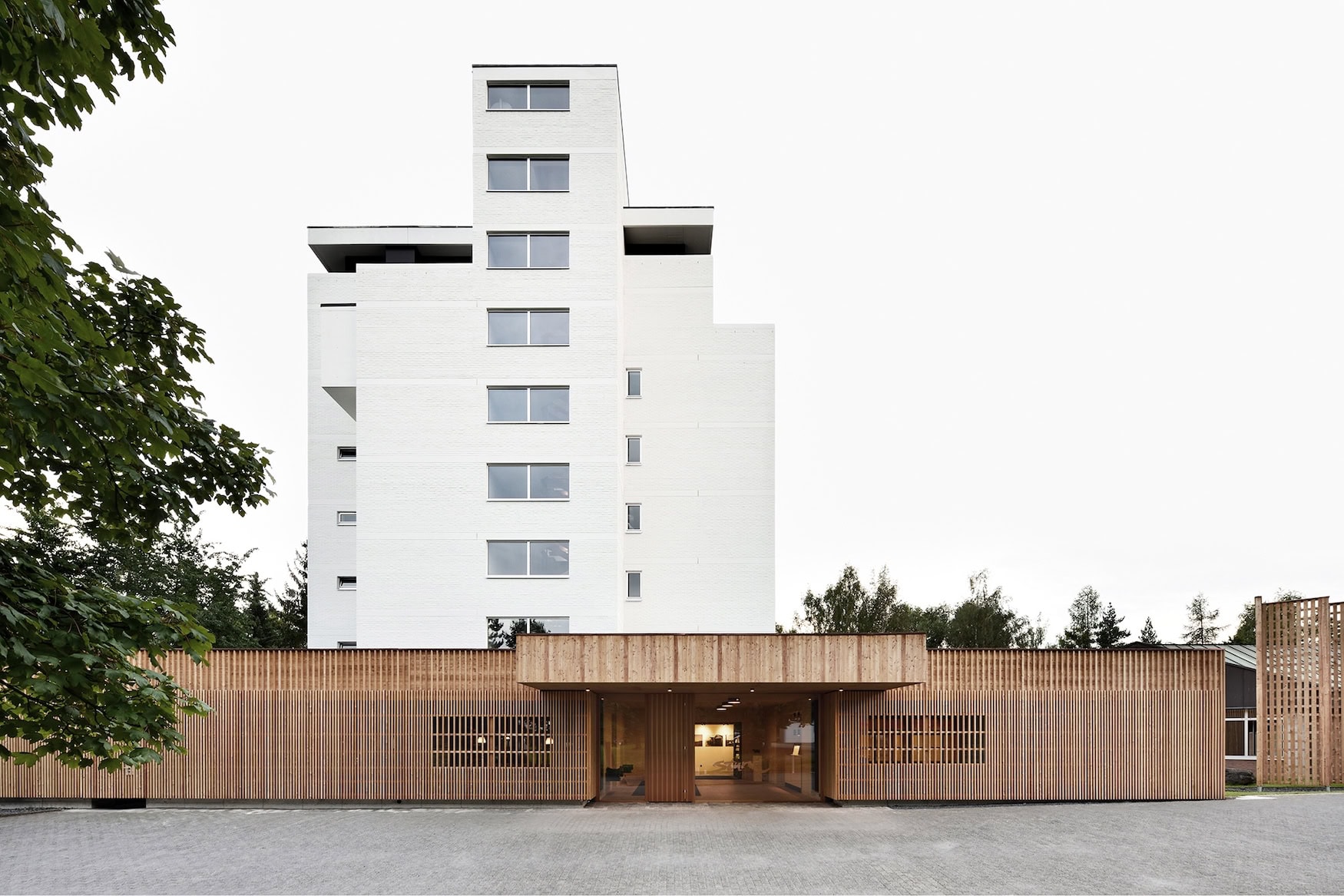 Perlweißer Hotelturm des Biohotels Sturm mit vorgelagertem Eingangsbau aus einer Holzlamellenfassade
