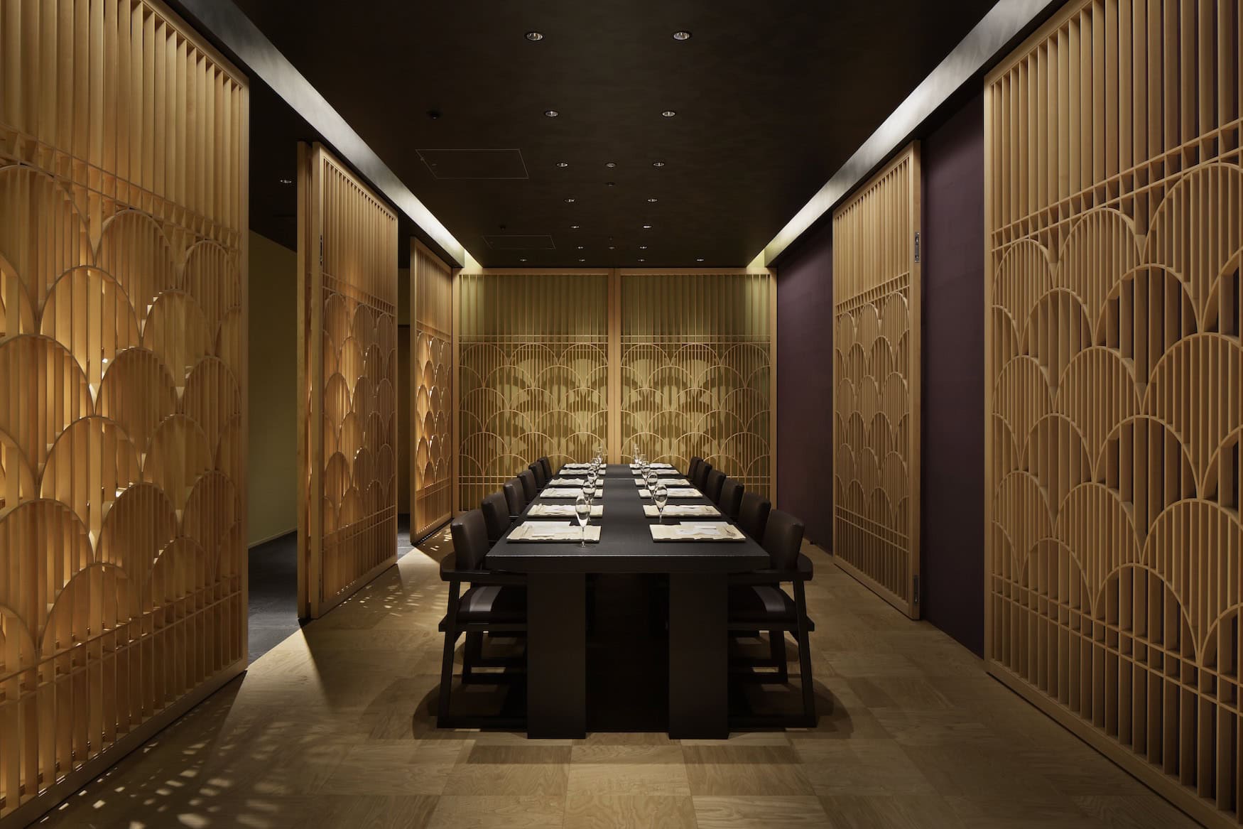 Restaurant im HOSHINOYA Tokyo mit langer Tafel und holzverkleideten Wänden im Wellenmuster