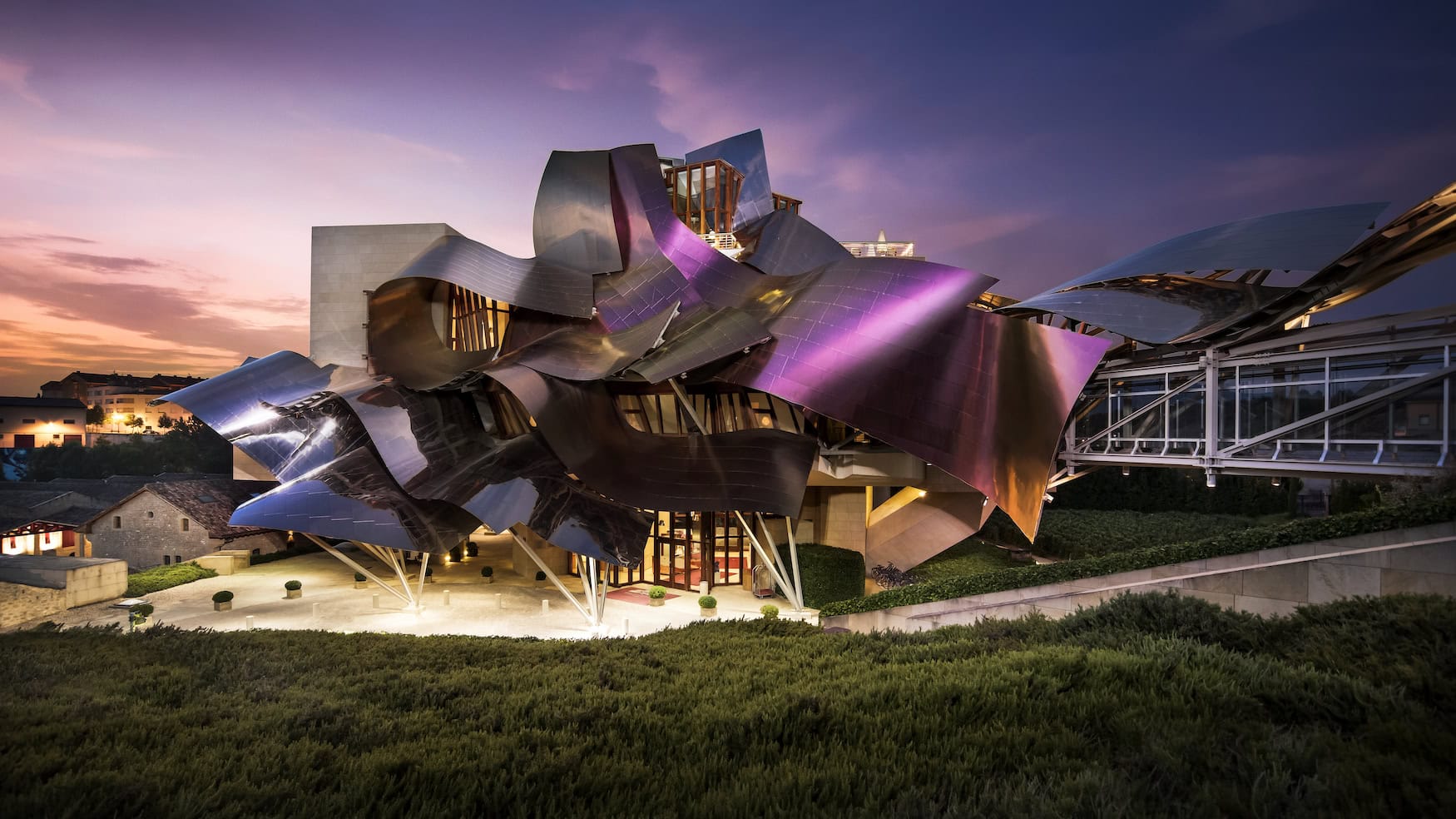 Geschwungene Titanfassade des Hotels Marqués de Riscal von Frank Gehry in der Abenddämmerung