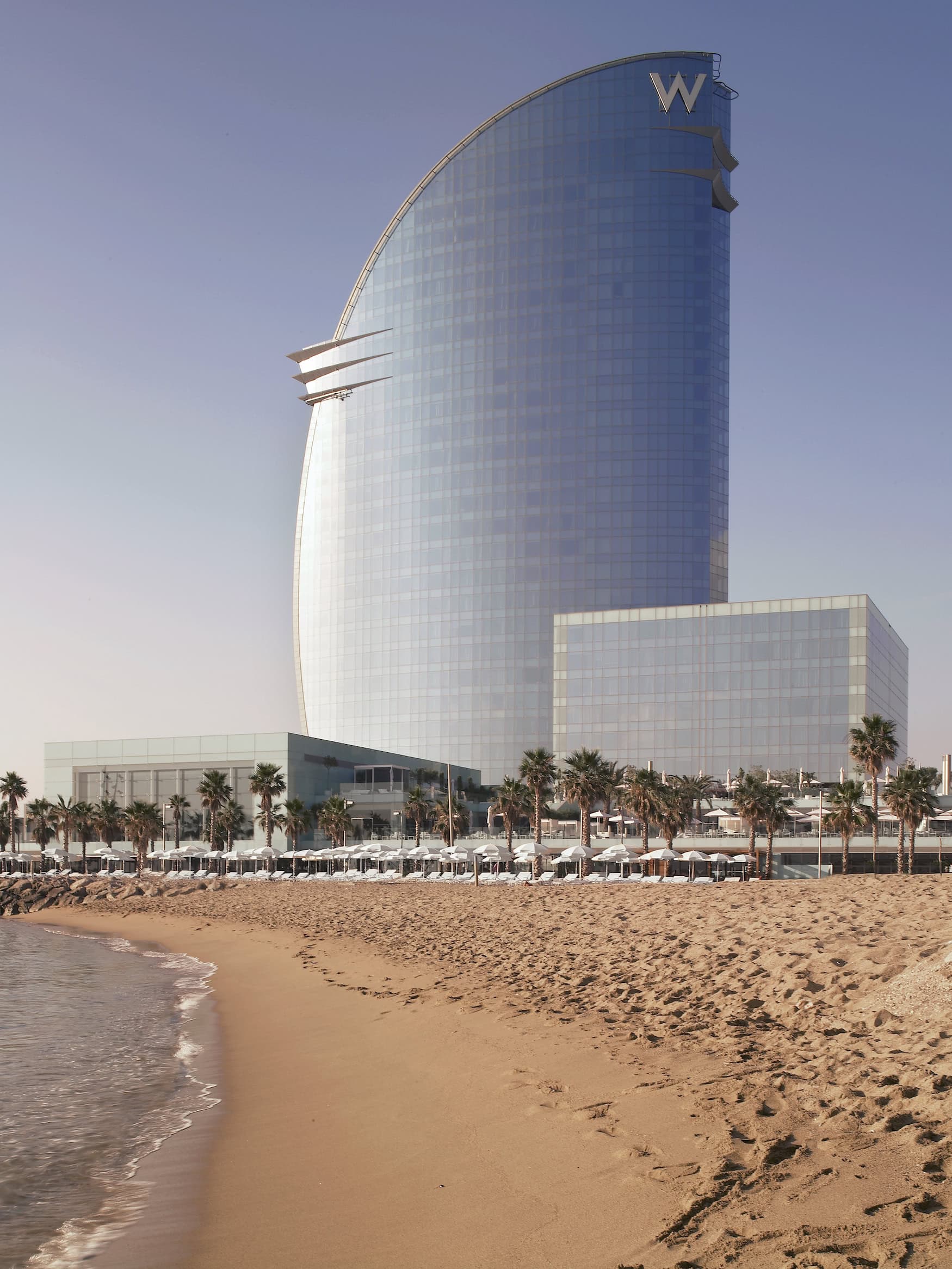 Segelförmige Glasfassade des W Barcelona am Strand der Barceloneta