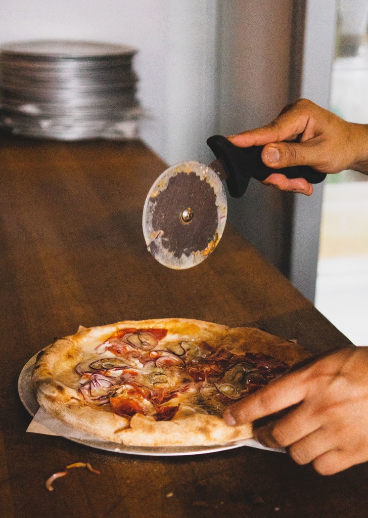 Pizza wird in einer Trattoria geschnitten