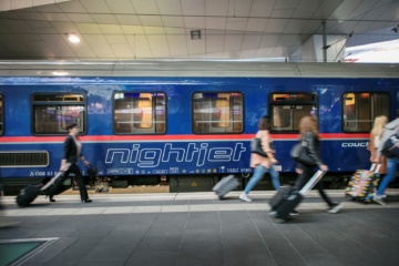 Fahrgäste gehen an Nightjet-Waggon der ÖBB vorbei