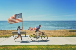 Junge und Mädchen mit USA-Flaggen am Meer