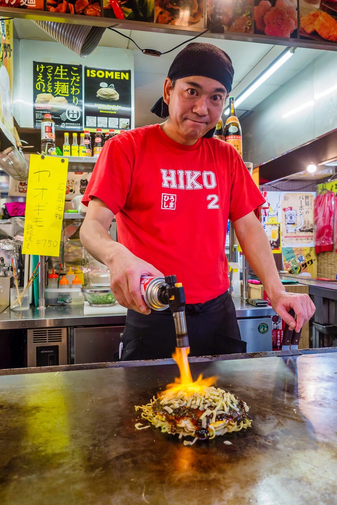 Mann grillt japanische Pfannkuchen in einem Restaurant in Osaka