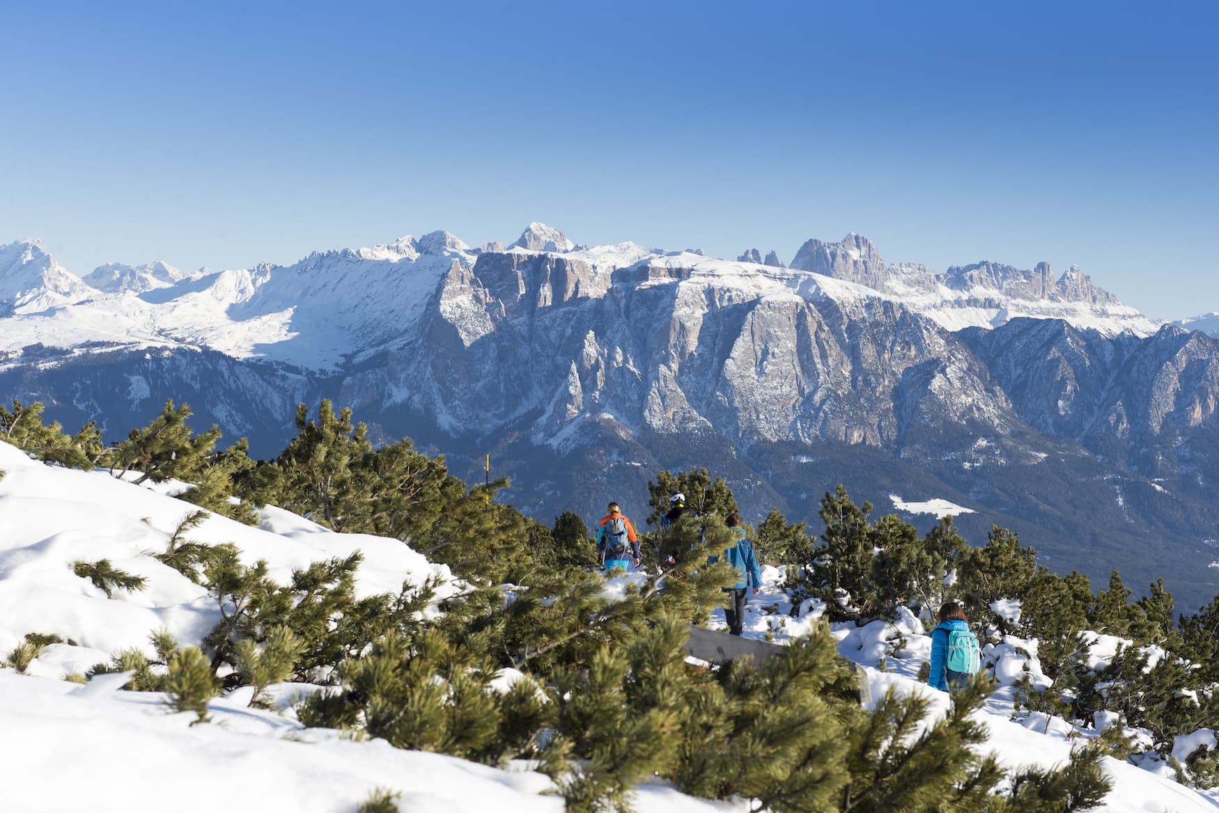 Familie wandert durch verschneite Landschaft in Ritten in Südtirol