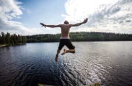Junger Mann springt in einen See