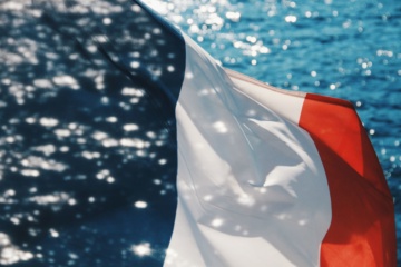 Wehende Frankreich-Flagge, im Hintergrund Meer