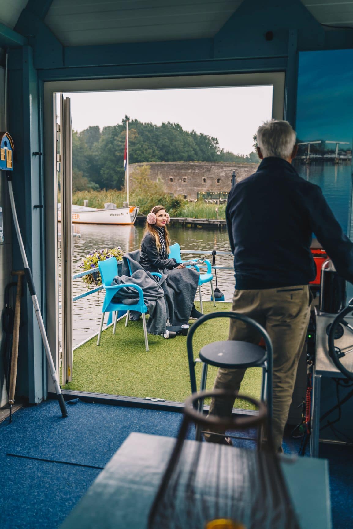 Kapitän und junge Frau während Bootstour auf dem Fluss Vecht in der Nähe von Amsterdam