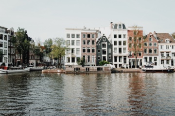 Schmale Häuser an Fluss in Amsterdam