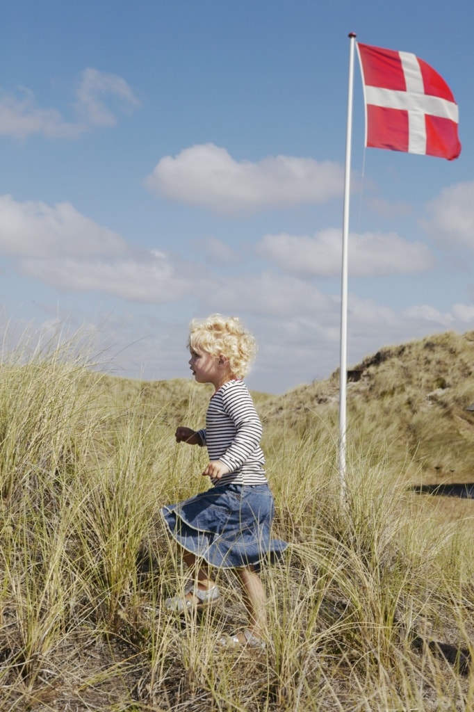 Mädchen läuft in Dänemark durch Dünenlandschaft 