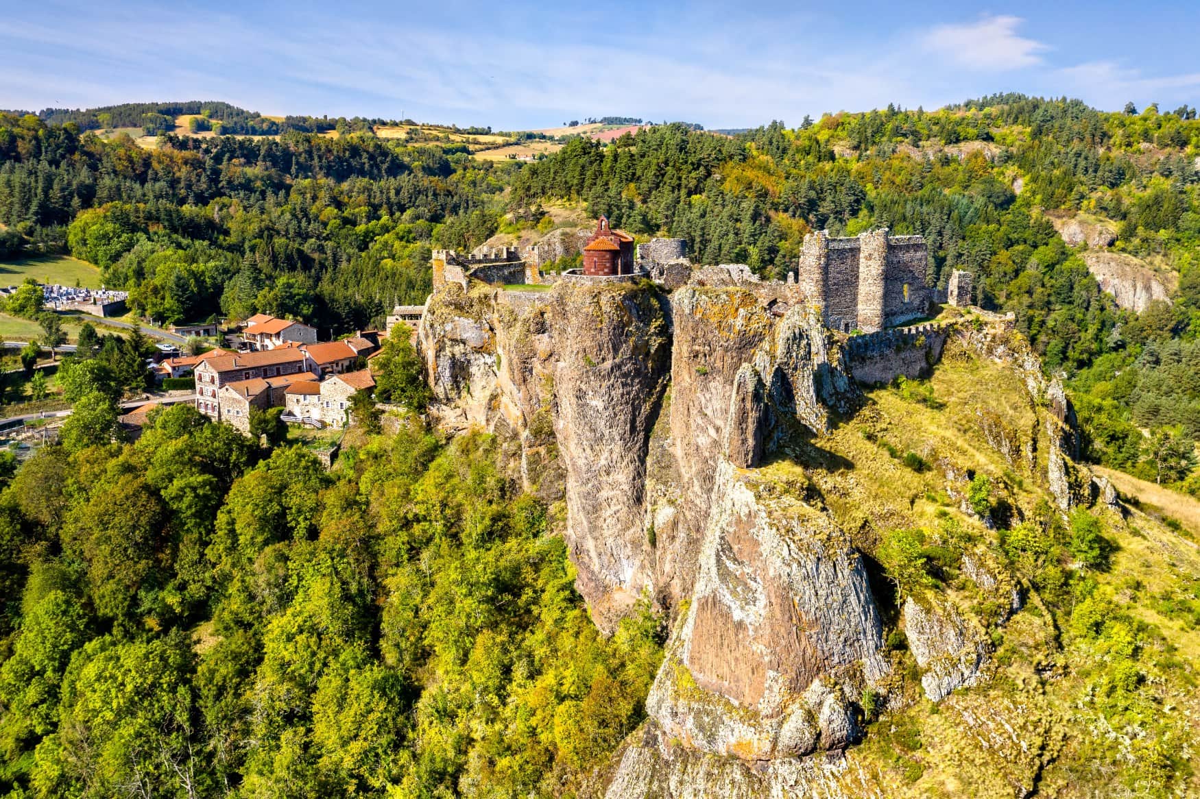 Das mittelalterliche Dorf Arlempdes in Frankreich, dominiert von einer Burgruine auf einem Felsvorsprung