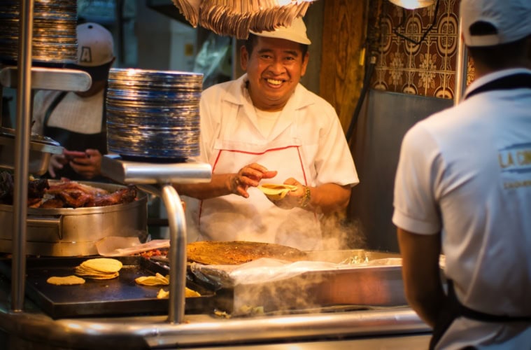 Ein Mann bereitet in Mexiko-Stadt Tacos zu.
