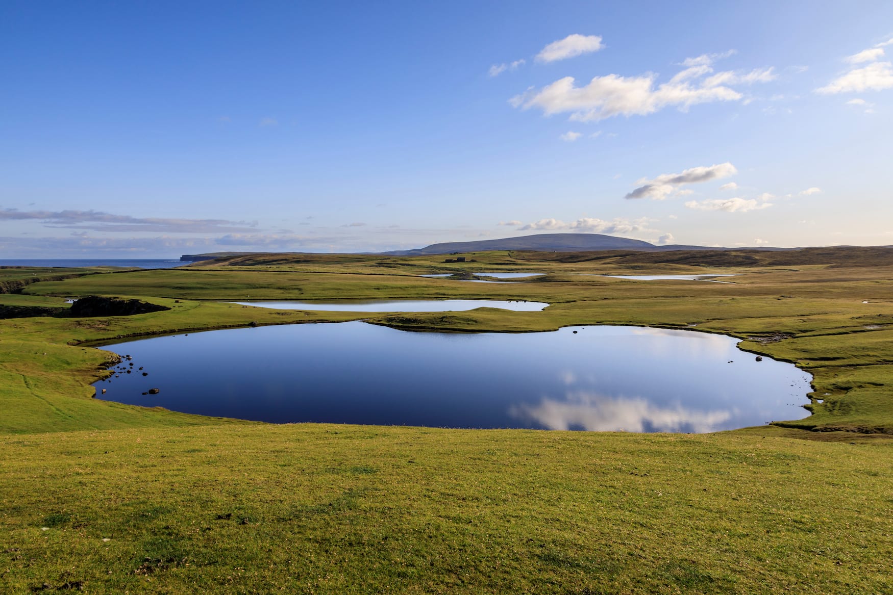 Spiegelungen auf dem Wasser des Loch Dridgeo auf den Shetland Inseln in Schottland