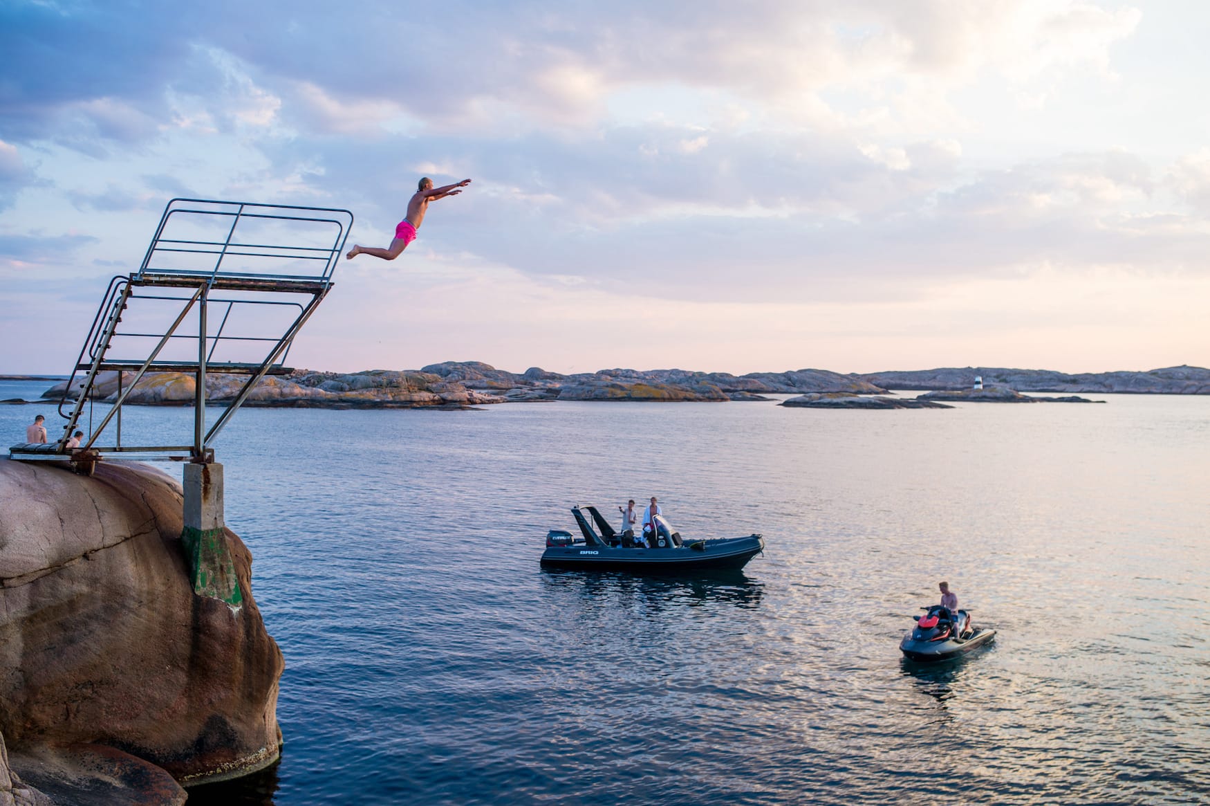 Menschen springen in das Wasser vor der Küste Schwedens