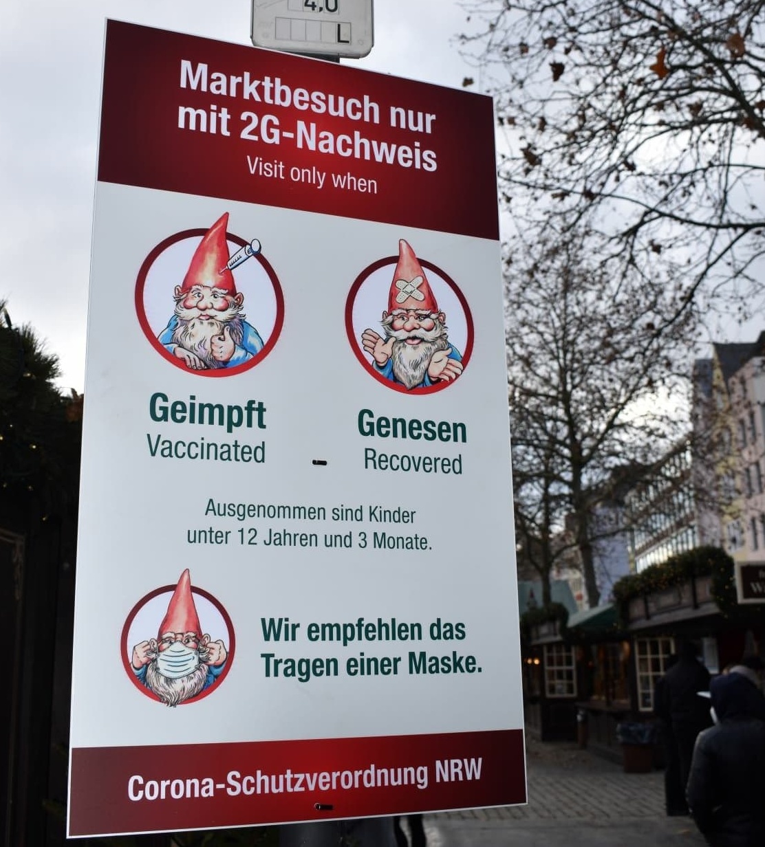Corona-Hinweisschild am Eingang des Weihnachtsmarktes auf dem Heumarkt in Köln 