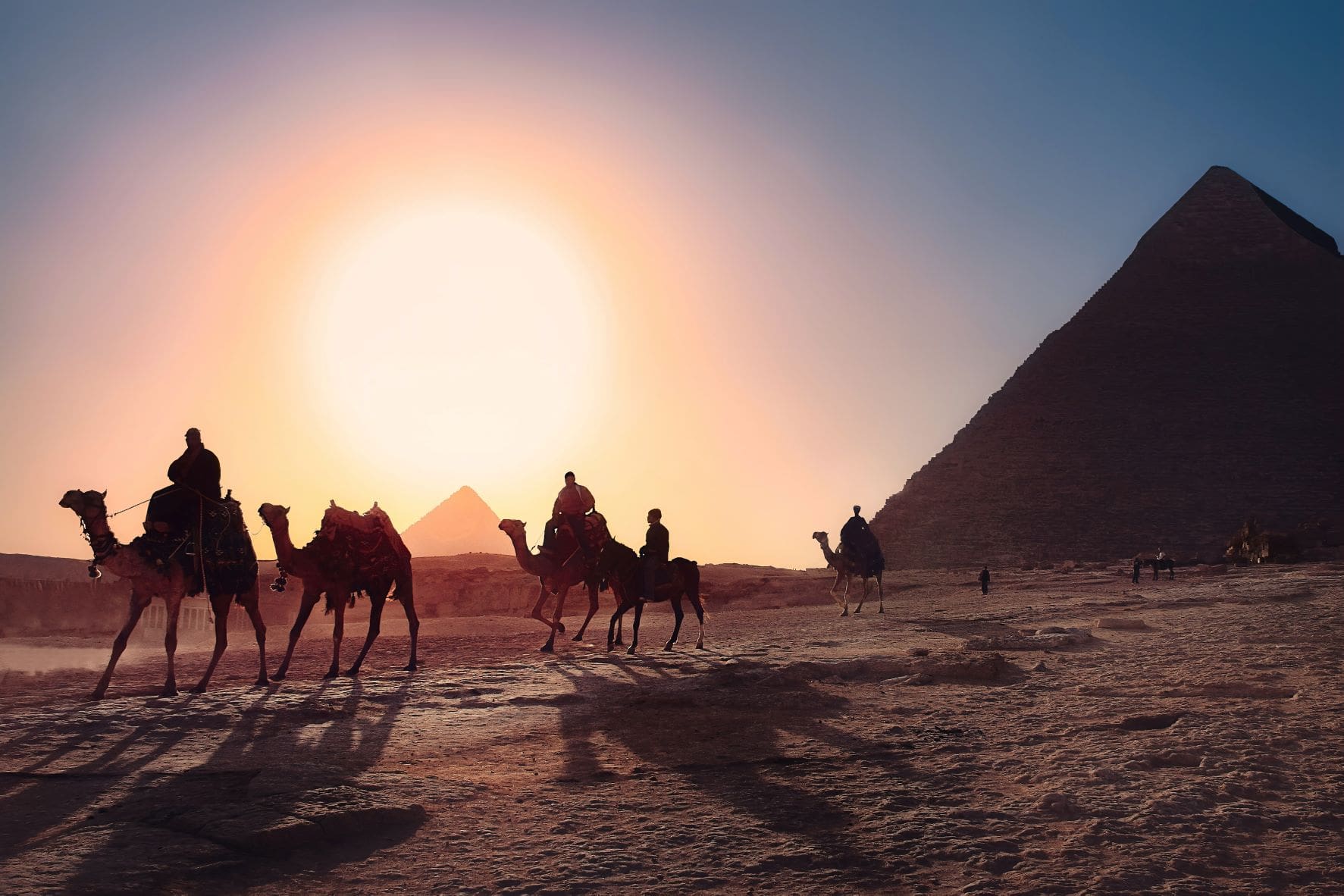 Kamel-Reitende in Ägypten, im Hintergrund Pyramiden 