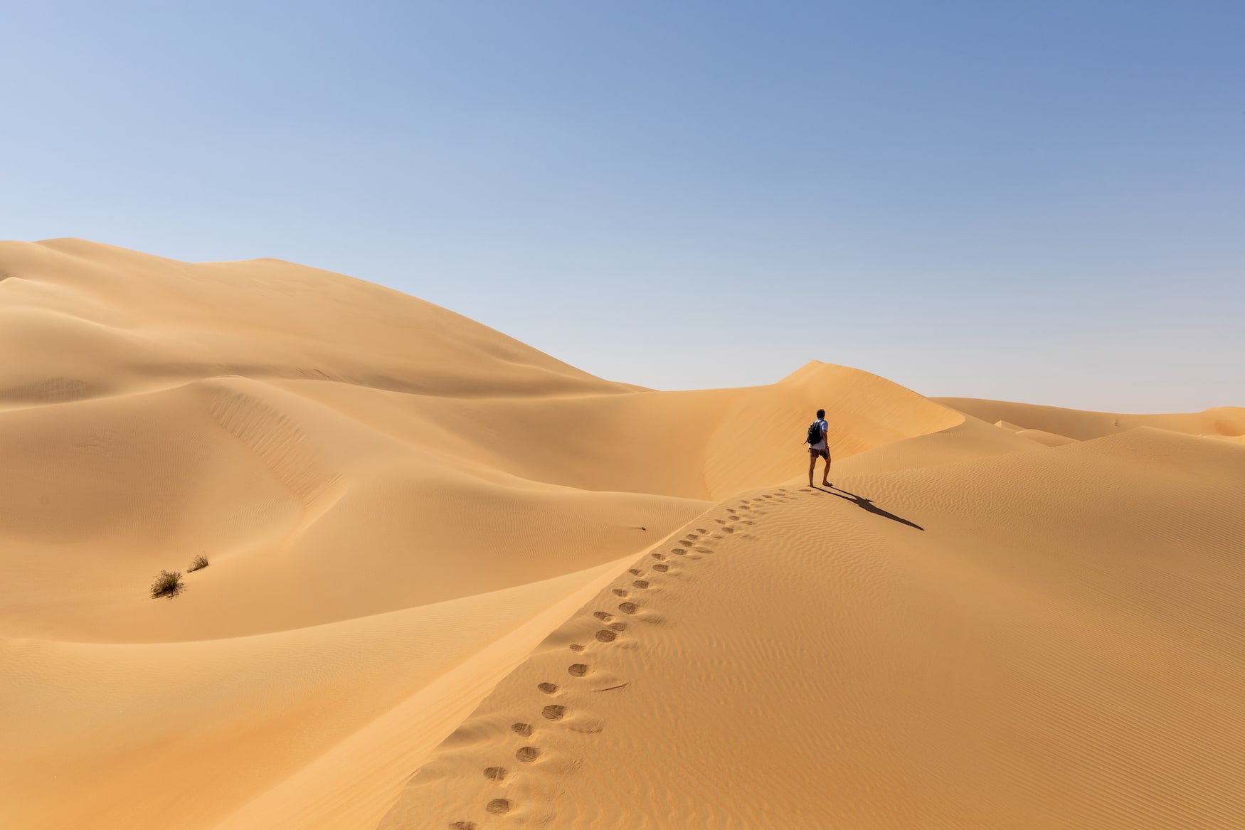 Mann spaziert über die Dünen in der Liga Wüste
