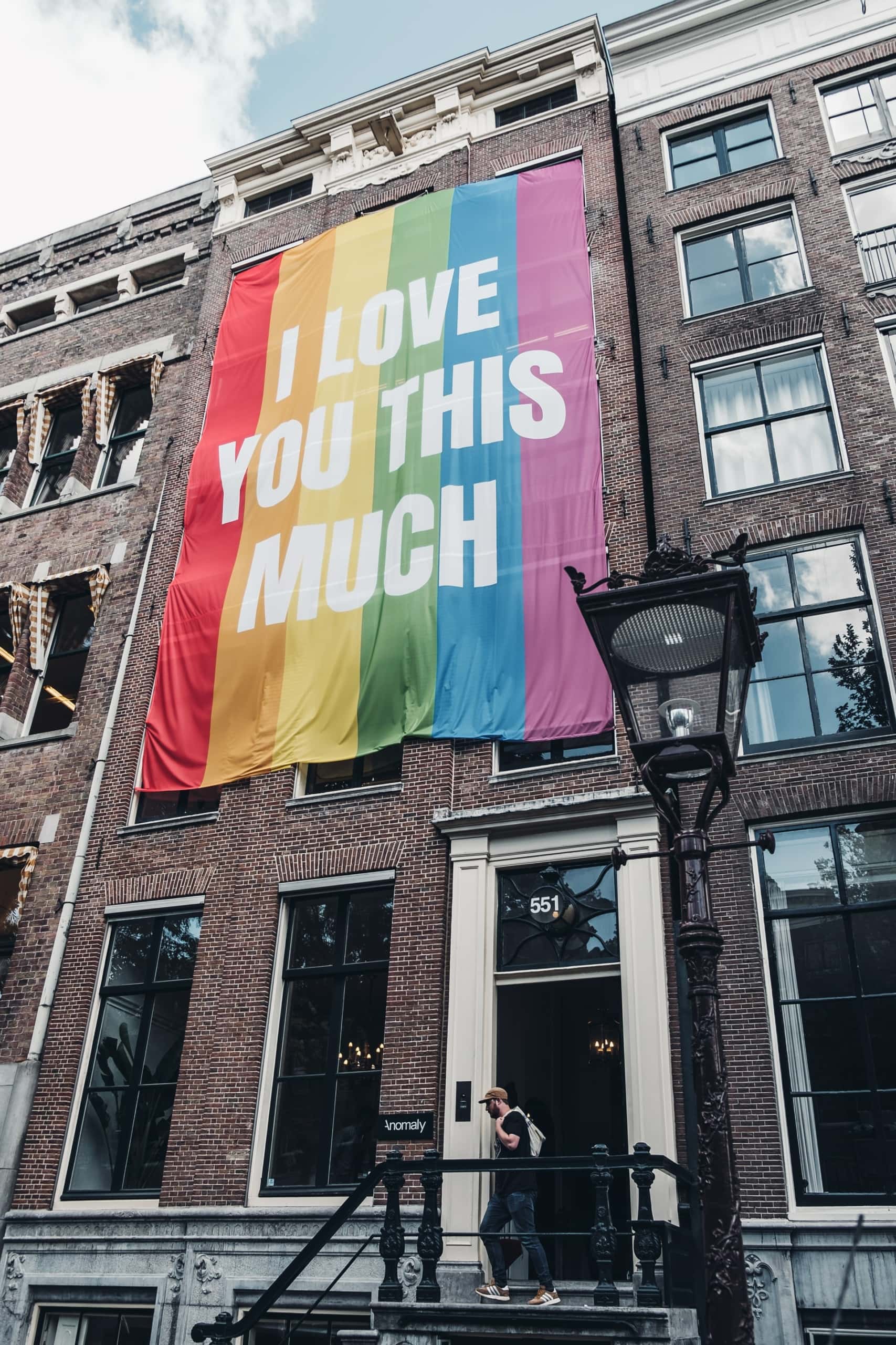 Regenbogen-Fahne mit der Aufschrift "I love you this much", das ein Haus in Amsterdam ziert 
