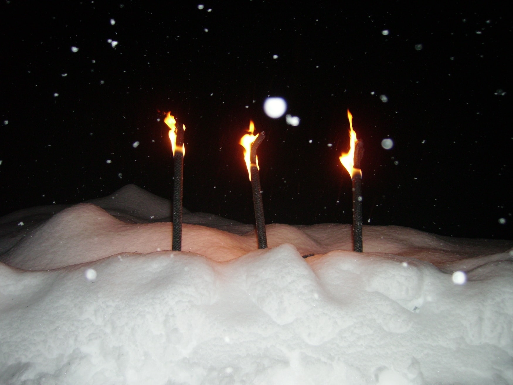 Fackelwanderung in Sexten, Südtirol, im Winter bei Dunkelheit