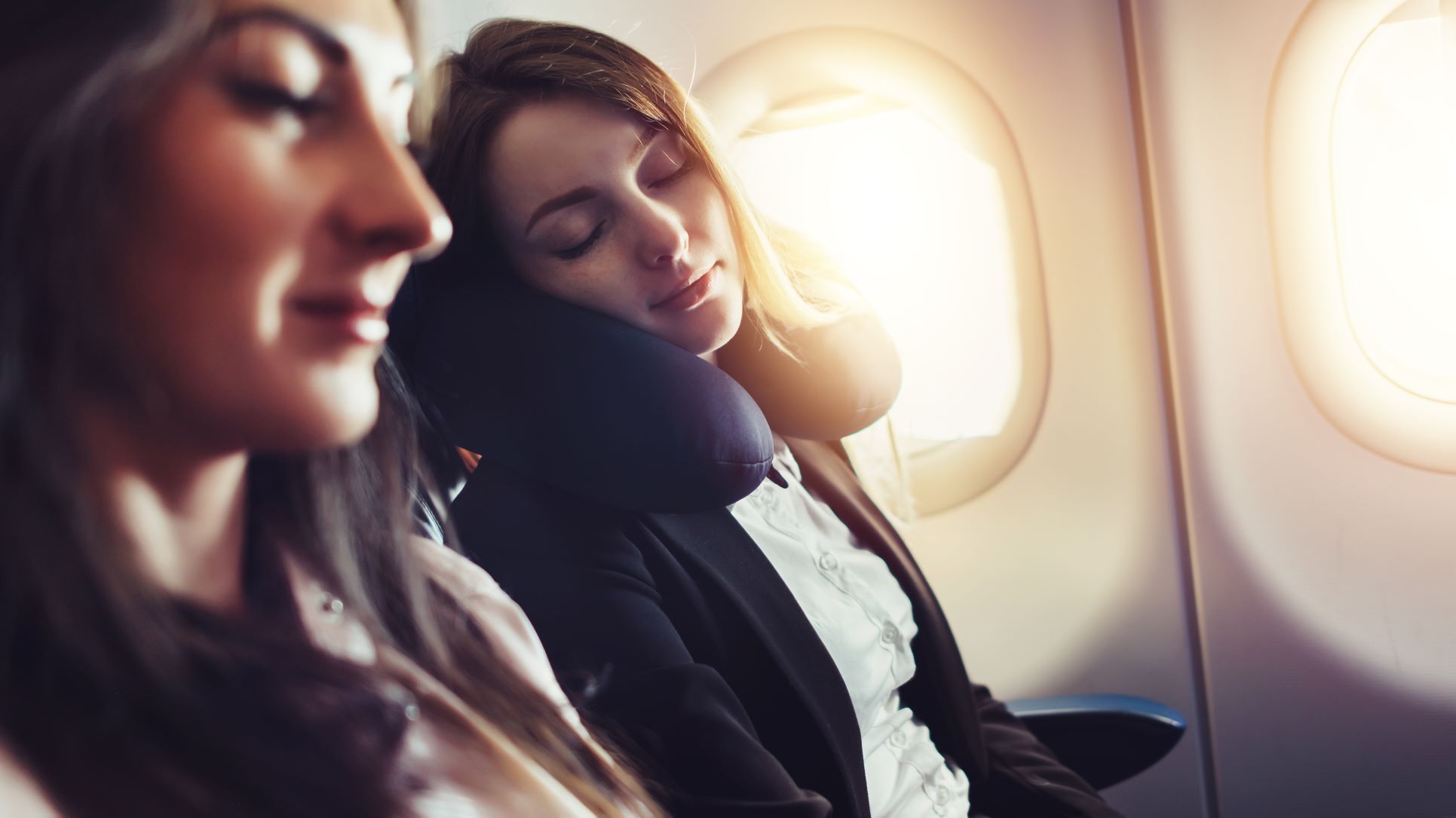 Zwei junge Frauen sitzen im Flugzeug 