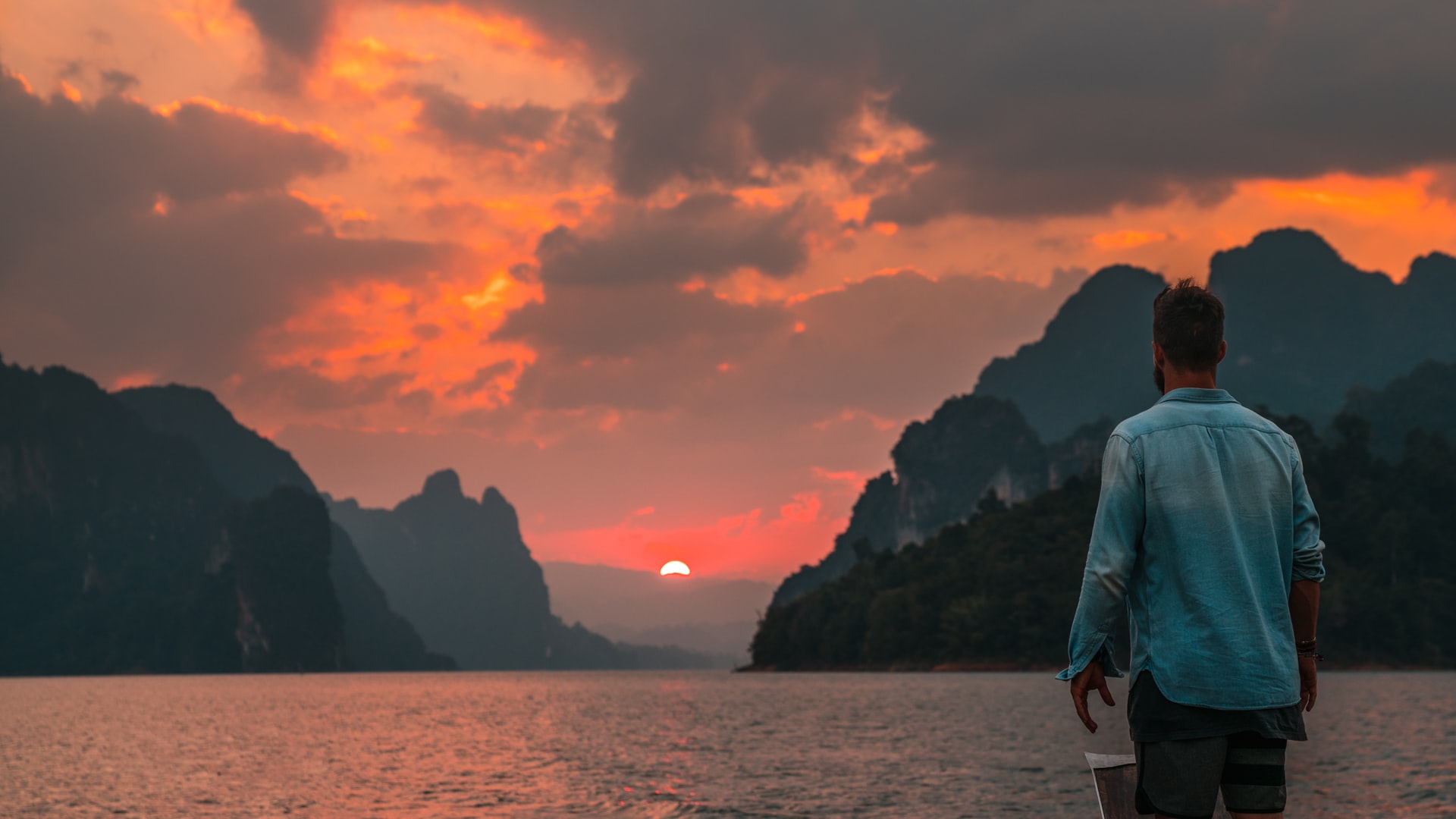 Tourist in Thailand beobachtet Sonnenuntergang am Meer 
