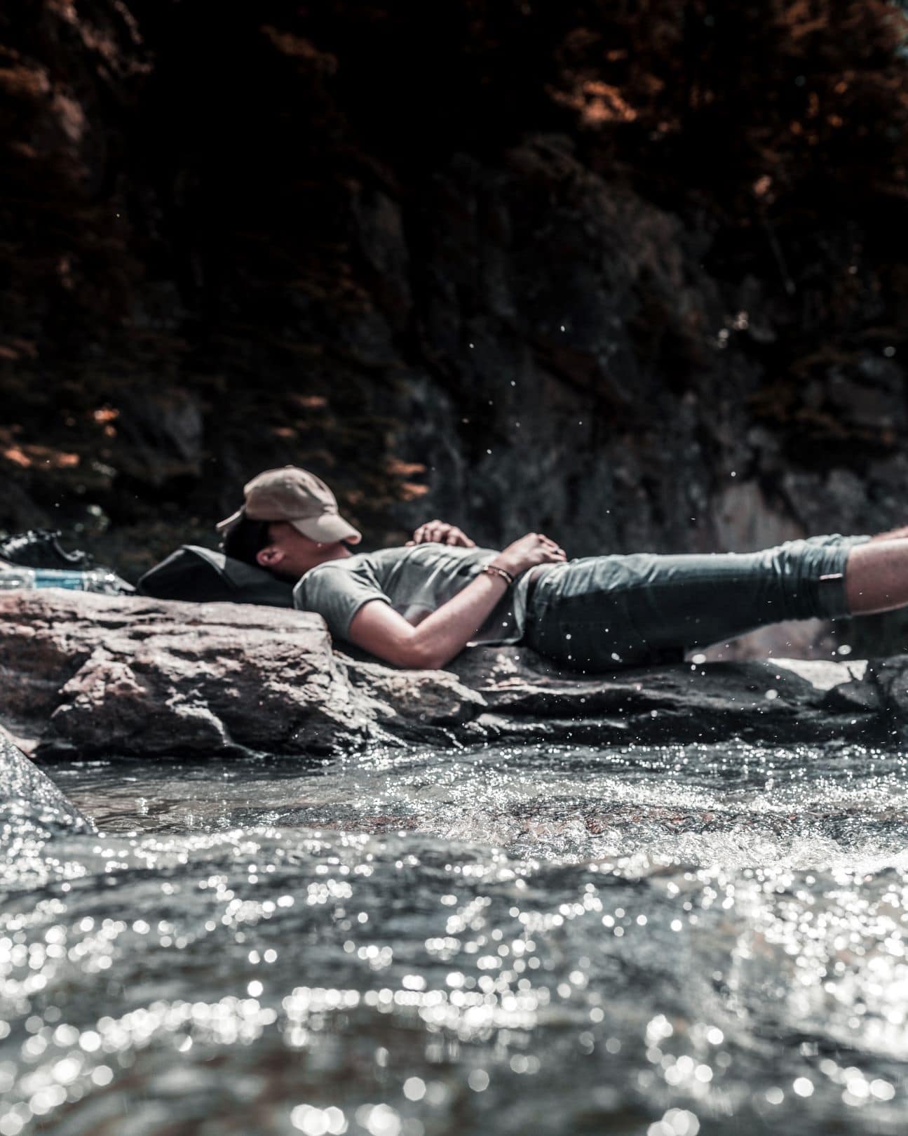Junger Mann chillt auf Felsen am Fluss 