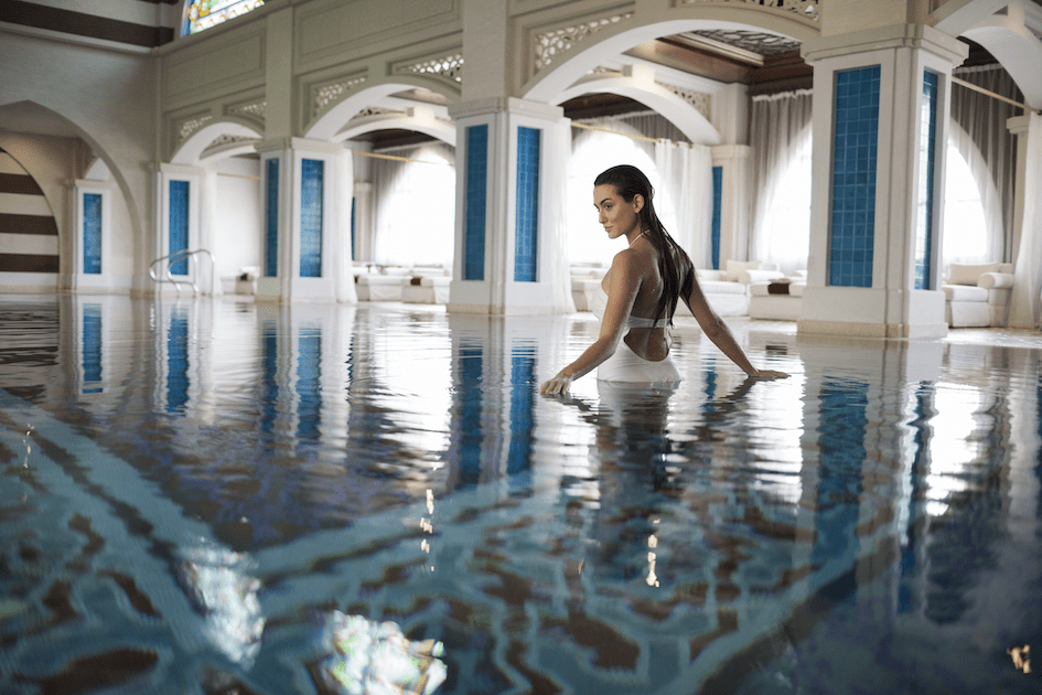 Junge Frau steigt aus Pool im Spa des Jumeirah Zabeel Saray