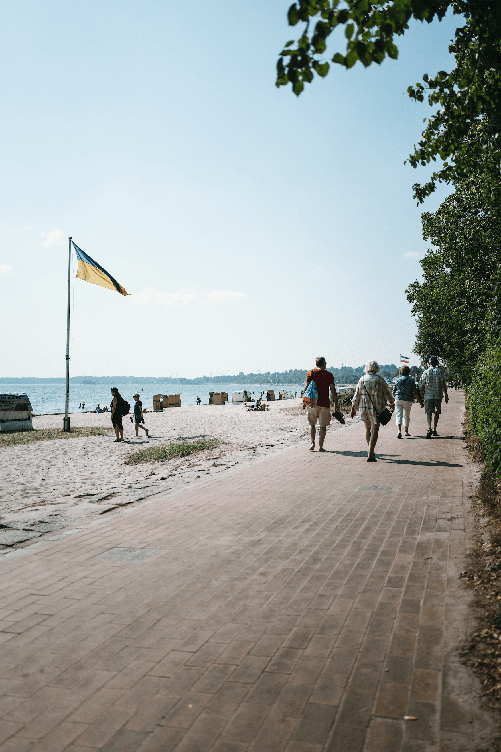 Menschen spazieren auf der Strandpromenade in Eckernförde
